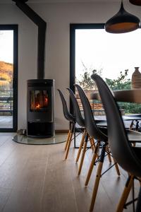 a room with a table and chairs and a fireplace at Villa calme avec vue 4 à 8 personnes - salle de sport in Saint-Amarin