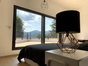 a bedroom with a bed and a large window at Villa calme avec vue 4 à 8 personnes - salle de sport in Saint-Amarin +33 photos