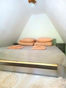a bed with pillows on it in a attic at Котедж Синевир in Synevyr