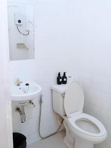 a white bathroom with a toilet and a sink at Toss Inn Sang Chan - Hat Yai in Hat Yai +21 photos
