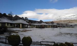 a group of houses with snow on the roofs at Fairways Resort Drakensberg in Drakensberg Garden