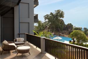a balcony with a table and chairs and a pool at Swiss-Belresort Belitung in Tanjungbinga