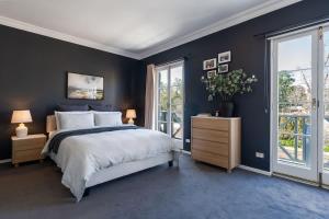 ein Schlafzimmer mit einem großen Bett und blauen Wänden in der Unterkunft 3 Bed Close To City Adelaide Oval Golf Course in North Adelaide