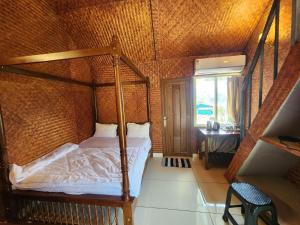 a bedroom with a canopy bed and a window at Tusker Valley Bamboo Room Mudumalai by Privacy Homes in Mudumalai National Park