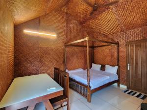 a bedroom with a bed and a table in a room at Tusker Valley Bamboo Room Mudumalai by Privacy Homes in Mudumalai National Park +5 photos