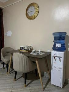 a dining room table with a clock on the wall at Jaza homes in Baruti West