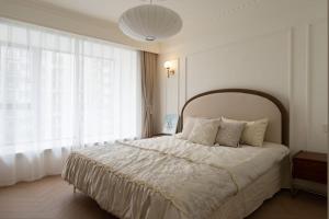 a bedroom with a large bed and a large window at EHUB - Enjoy Shanghai Tower View with Floating Window, near Yuyuan Garden and the Bund in Shanghai +19 photos