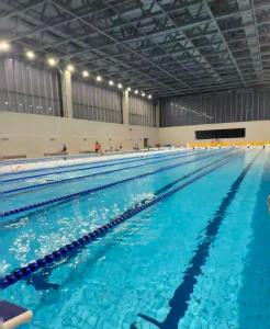 a large indoor swimming pool with blue water at EHUB - Enjoy Shanghai Tower View with Floating Window, near Yuyuan Garden and the Bund in Shanghai