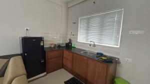 een keuken met een zwarte koelkast en een spoelbak bij Le divines in Guruvāyūr