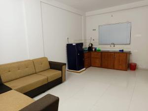 een woonkamer met een bank en een tv bij Le divines in Guruvāyūr