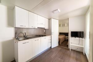 a white kitchen with white cabinets and a sink at Villaggio Capo Vieste in Vieste