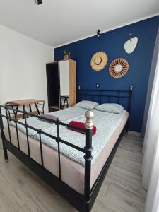a bedroom with a bed with a blue wall at Kraken Rooms in Kołobrzeg