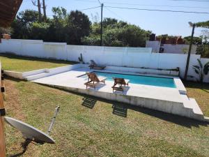 a swimming pool with two chairs and a table at Ponta Serenity Spot in Lopes +12 photos