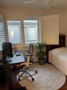 DeagonにあるRoom in a Lovely Houseのパソコンとベッドのある机のある寝室