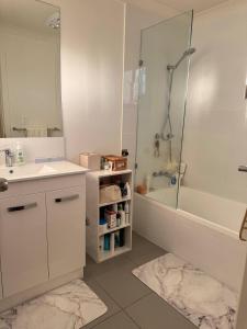 DeagonにあるRoom in a Lovely Houseの浴槽、洗面台、シャワーを備えたバスルーム