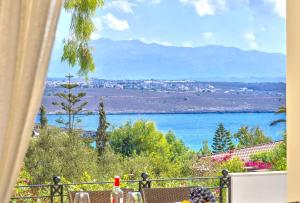 a view of a body of water from a balcony at Luxury Seaside Villa Plumeria ,50m to Sandy Beach, Chania in Tersanas