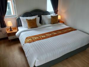 a large bed in a hotel room with two lamps at The white resort & restaurant koh yao yai in Ban Khlong Hia