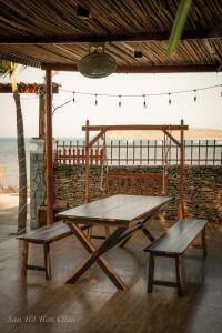 Una mesa de picnic y dos bancos frente al océano. en San Hô Hòn Chùa Home, en Mỹ Quang