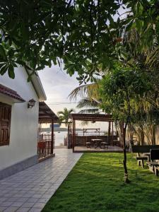 un patio con mesa, bancos y agua en San Hô Hòn Chùa Home, en Mỹ Quang