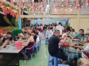 a group of people sitting at tables in a restaurant at Nam Du VIEW Guest House in Nam Du