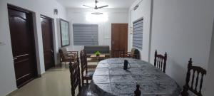 a dining room with a table and chairs in a room at Vedic Nirvana Home Stays & Rooms in Irinjālakuda