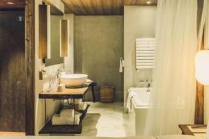 a bathroom with a sink and a bath tub at Tsingpu Tulou Retreat 青普文化行馆 南靖土楼店 in Nanjing