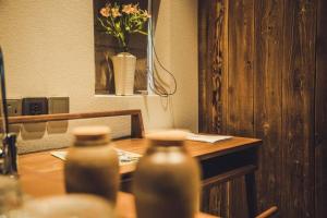 two bottles on a wooden table with a vase of flowers at Tsingpu Tulou Retreat 青普文化行馆 南靖土楼店 in Nanjing