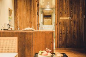 a kitchen with a sink and a bowl of fruit on a table at Tsingpu Tulou Retreat 青普文化行馆 南靖土楼店 in Nanjing +63 photos
