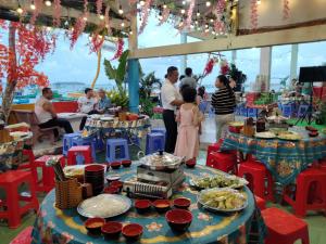 a group of people standing around a table with food at Nam Du VIEW Guest House in Nam Du