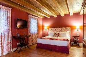 a bedroom with red walls and a bed and a tv at Fiori e Frutti Agriresort in Mestre
