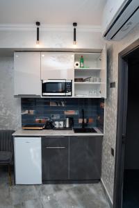 a kitchen with white cabinets and a sink at Prime Suites Hotel in Yerevan +66 photos