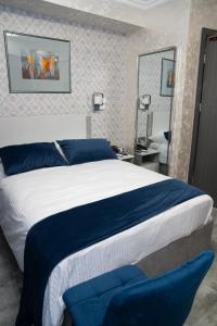 a bedroom with a blue and white bed and a mirror at Prime Suites Hotel in Yerevan