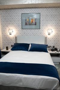 a bedroom with a large bed with blue pillows at Prime Suites Hotel in Yerevan
