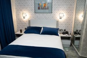 a bedroom with a blue and white bed and a mirror at Prime Suites Hotel in Yerevan
