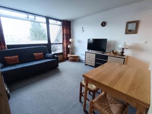 a living room with a couch and a table at À deux pas des pistes in Aragnouet +1 photo