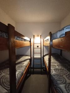 a room with two bunk beds in a room at À deux pas des pistes in Aragnouet
