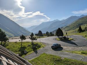 a car parked on a road with mountains in the background at À deux pas des pistes in Aragnouet
