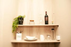 a shelf with a bottle of wine and glasses at Pine & Pebble in Centurion