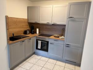 a kitchen with white cabinets and a stove top oven at Hohner-Auszeit in Bad Münstereifel +7 photos