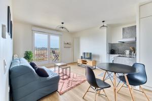 a living room with a blue couch and a table at Apartment 10 minutes from Paris well connected-Metro 4 in Bagneux
