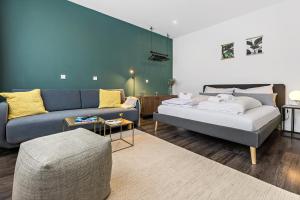 un salon avec un lit et un canapé dans l'établissement LUXOMES - Modern Design Apartments - Ingolstadt Central, à Ingolstadt