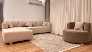a living room with a couch and a chair at Luxurious and hotel-like accommodation with garden view in New cairo