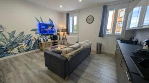 Una sala de estar con un sofá y un televisor. en Castellane : T2 spacieux - Vue Port - WIFI, en Port-Vendres