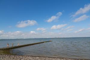 a group of people standing on a pier in the water at Ferienwohnung Butjenter Brise in Stick