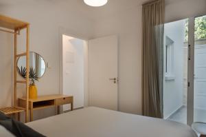 a bedroom with a bed and a mirror and a table at Sienna Townhouse by Staycom in Paphos City +8 photos