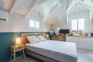 Un dormitorio con una cama y un escritorio con una computadora. en Kaz Bel Horizon, vue mer panoramique et piscine privée au Gosier, en Le Gosier 27 fotos más