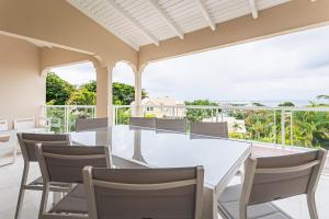 Un comedor con una mesa y sillas blancas. en Kaz Bel Horizon, vue mer panoramique et piscine privée au Gosier, en Le Gosier