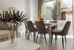 a dining room with a white table and chairs at Sienna Townhouse by Staycom in Paphos City