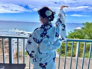 a woman in a kimono standing in front of the ocean at Ajisai Coral Princess Villa in Shirahama +28 photos