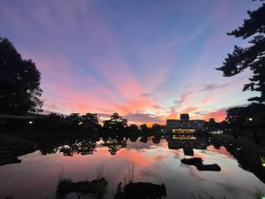 奈良Yoshidaya Ryokan よしだや的夕阳西下，水面上矗立着一栋建筑